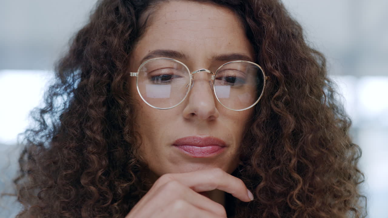 Serious woman, thinking and working on a laptop as