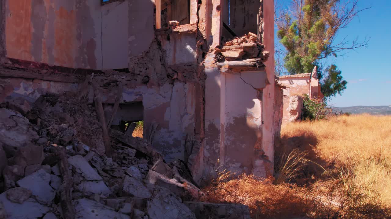 Passing by a destroyed building to reveal the fields of olive trees