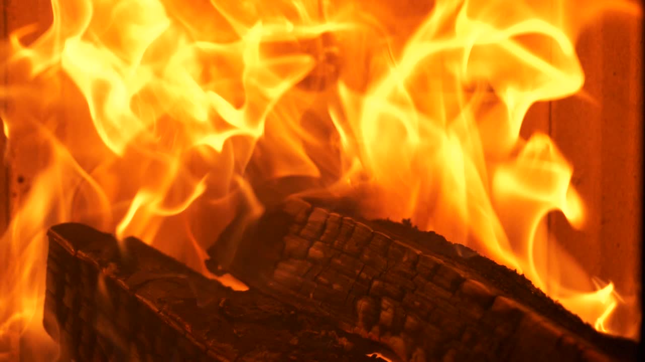 Warm cozy fire burning in a fireplace, slow motion close up