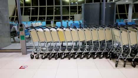 trolleys being moved orderly inside bangkok suvarnabhumi airport terminal area