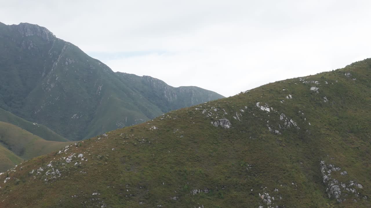 남아프리카 공화국 웨스턴 케이프의 아우테니쿠아 산꼭대기에서 찍은 공중 촬영. 드론은 왼쪽으로 이동하여 웅장한 산맥과 광활한 풍경을 더 드러니다.