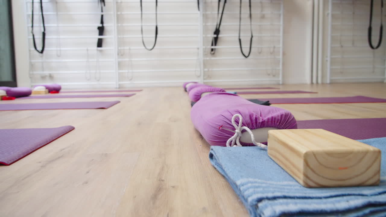 Studio di yoga vuoto con tappetini e attrezzatura su pavimento in legno