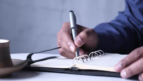 persona que escribe en un cuaderno