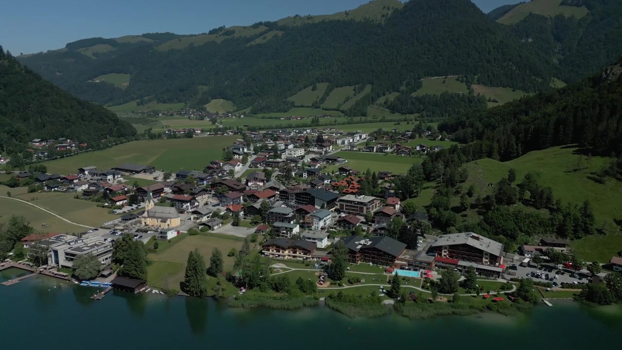 Un'ampia vista a volo d'uccello del pittoresco villaggio di Walchsee, situato direttamente sulle rive di un lago di montagna blu incontaminato