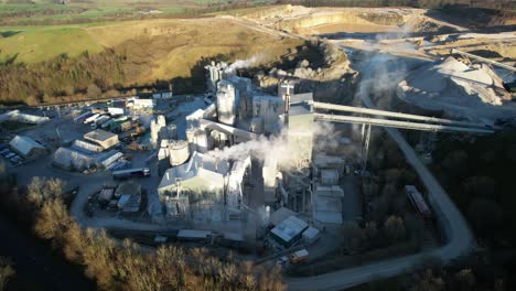 large industrial quarry with smoke from chimneys, in england, 4k aerial footage