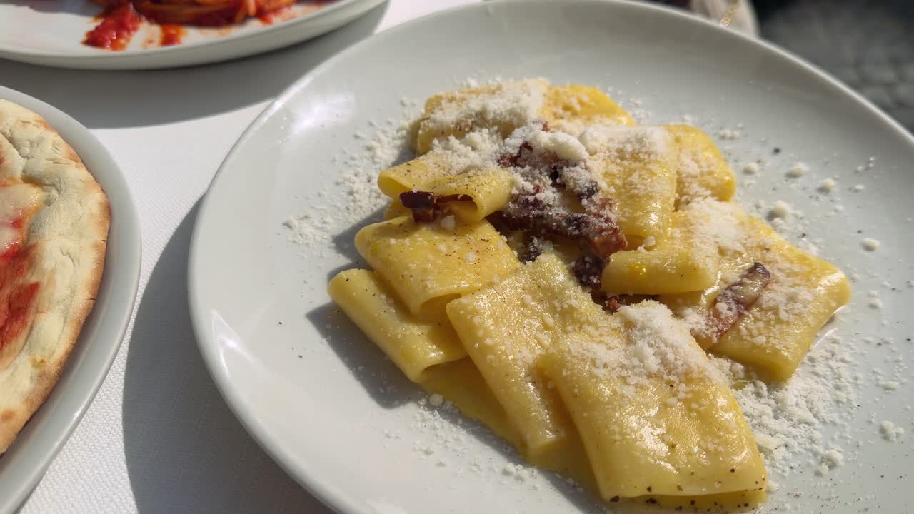 Deliziosi piatti italiani di pasta e pizza serviti in un ristorante all'aperto.