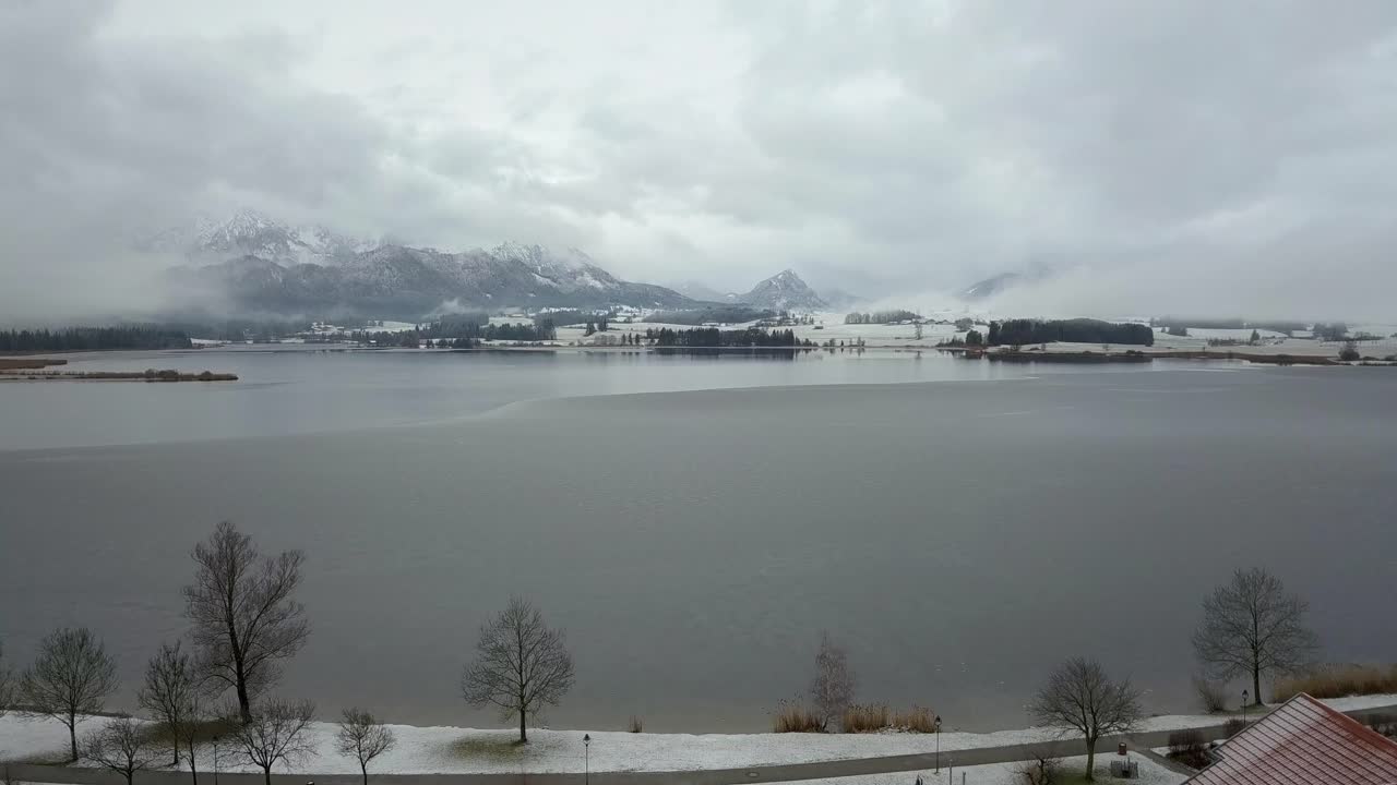 Hopfensee sjö med utsikt över Alperna på vintern.