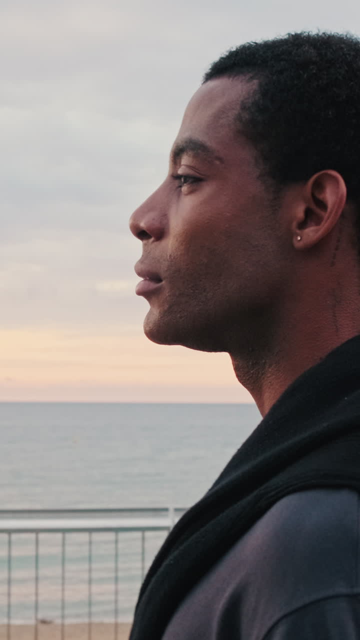 Young Man in Profile Looking Out at the Sea at Dusk
