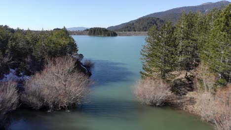 fast drone passing between two lake inlets sunny day