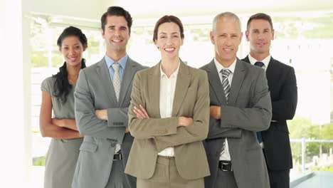 smiling business people looking at camera with arms crossed