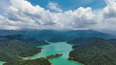 cinematic panoramic shot above fei-ts'ui reservoir with bright blue water and green jungle mountains, taiwan