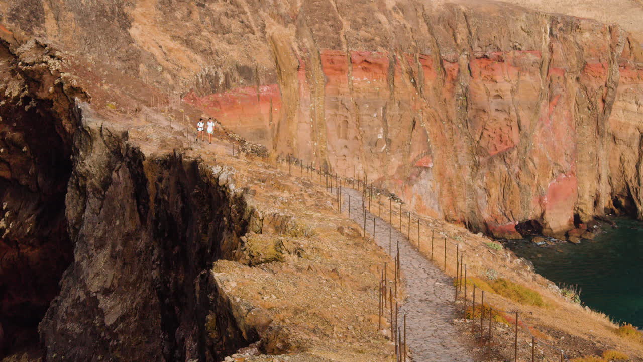 Couple Walking In Scenic Landscape Of Ponta De Sao in Madeira Portugal - wide shot