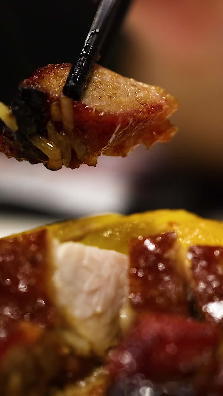 palillos para comer levantando una pieza de pato asado del plato