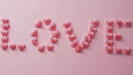 Love-text-of-heart-shape-sweets-on-pink-background-at-valentine's-day