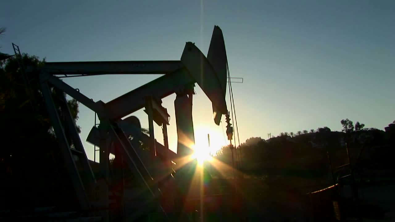 un gato de bomba se recorta contra el sol