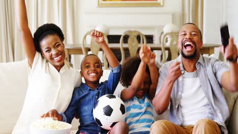 Padres-E-Hijos-Viendo-Partidos-De-Fútbol-En-La-Televisión-En-El-Salón.