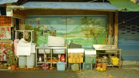 empty foodstand and washing basin all packed up and set aside at night in asia