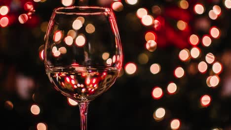 Christmas-party-background-with-glowing-Christmas-Tree-lights-and-glass-of-wine