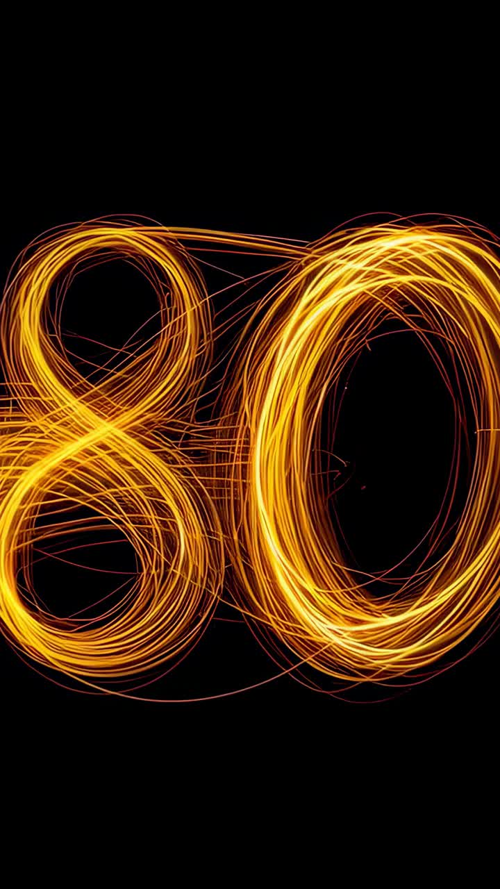 Vertical video: Waving sparkler tracing golden loops shifting right on dark void for light painting