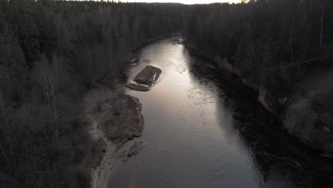 aerial flyover of river and forest mountains at sunrise