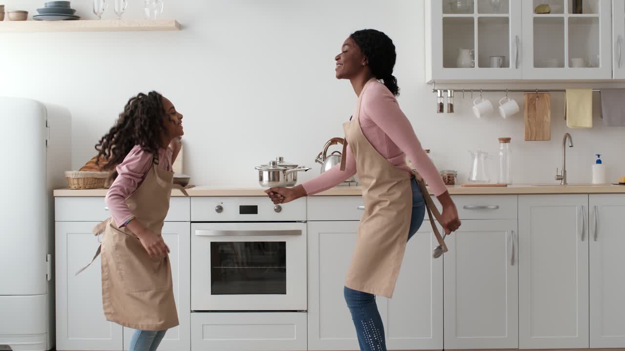 Madre e figlia ballano in cucina