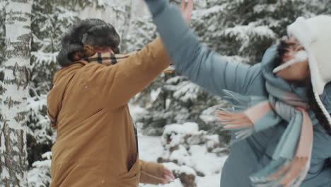 joyful girlfriends greeting each other at campsite in winter forest