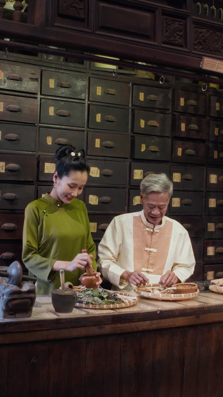 Asian Family in Traditional Clothes Working at Alternative Medicine Pharmacy