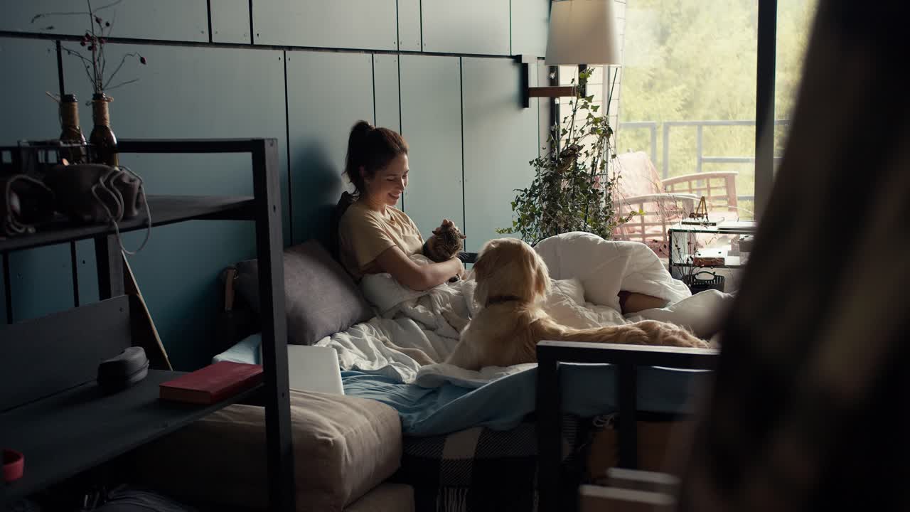 갈색 소녀가 개와 고양이  ⁇ 에 침대에 누워 있다. 주말에 애완동물과 놀고 있는 행복한 소녀