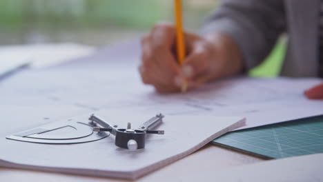 Nahaufnahme-Einer-Architektin-Im-Büro-Am-Schreibtisch,-Die-An-Plänen-Für-Ein-Neues-Gebäude-Arbeitet