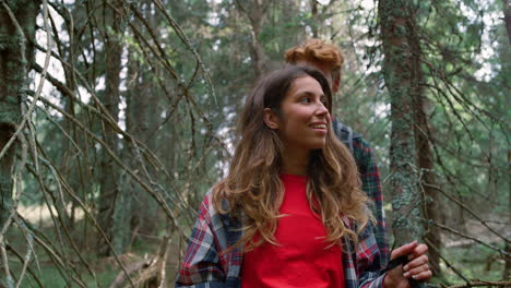 woman and man hiking in green forest