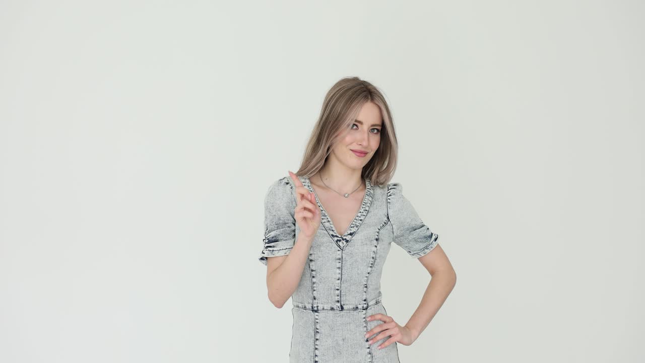 Woman in denim dress pointing