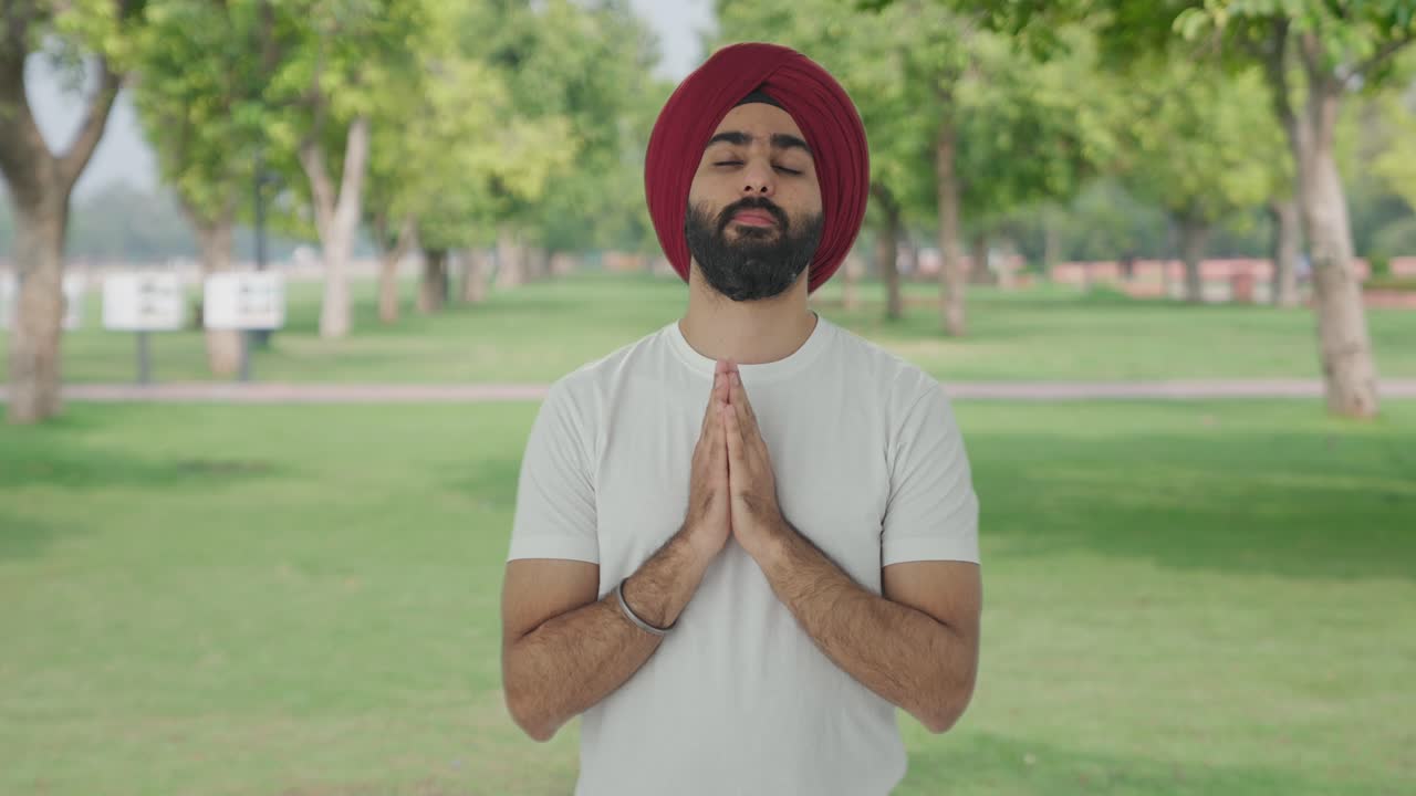 Religious Sikh Indian man praying to God in park