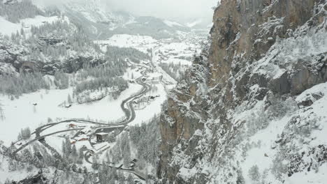 aerial of snow covered mountain ridge with a small swiss town in the background