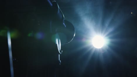 microphone on stage with blue smoke anding light behind it. low angle close shot handheld