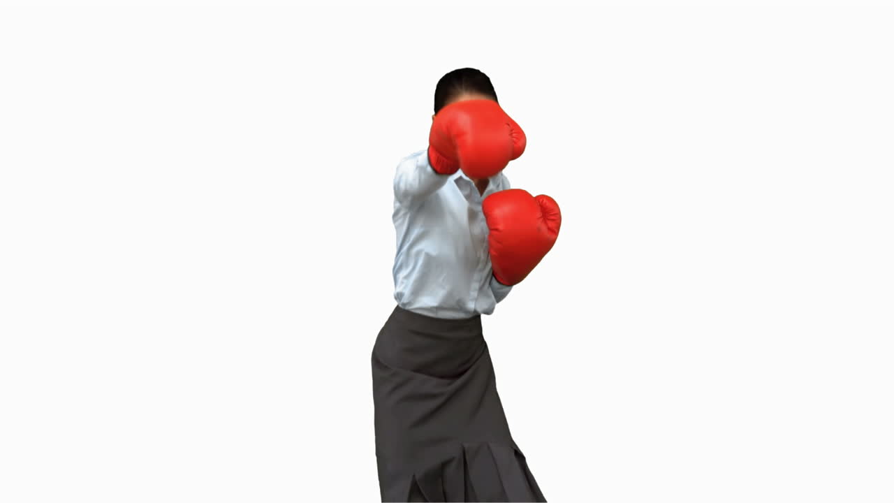 mujer de negocios con guantes de boxeo golpeando en la pantalla blanca