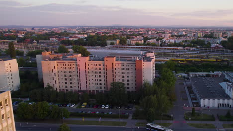 bloques de viviendas de sobrevuelo aéreo y estación de tren de cracovia en el fondo al amanecer en polonia