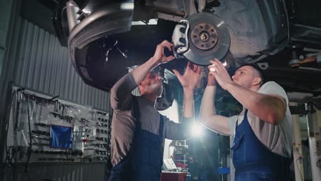 car repair technicians working under a car