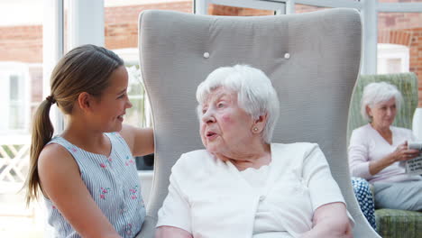 Nieta-Sentada-Y-Hablando-Con-La-Abuela-Durante-La-Visita-A-La-Casa-De-Retiro