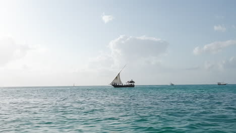 dhow boat sails in the ocean at sunny day, summer concept, zanzibar, tanzania