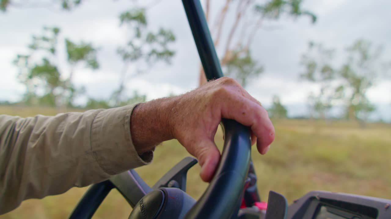 cierre la mano mientras conduce un quad en una granja en el norte de queensland, australia