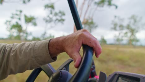 Hand-close-up-while-driving-a-quad-bike-on-a-farm-in-North-Queensland,-Australia