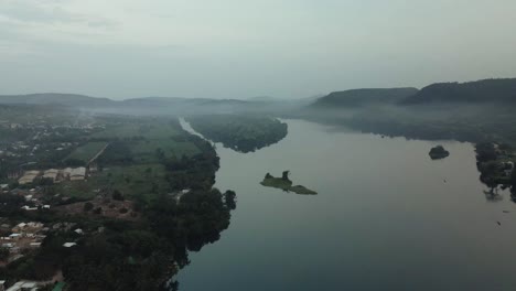 Toma-Aérea-Acercándose-A-La-Vista-De-Los-Edificios-Del-Pueblo-Y-La-Isla-En-El-Río-Volta.