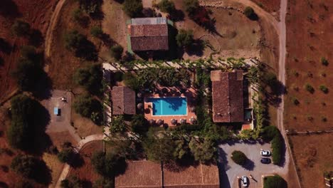 drone flight at the huge sunrise over the blue pool in the middle of some houses in palma de mallorca