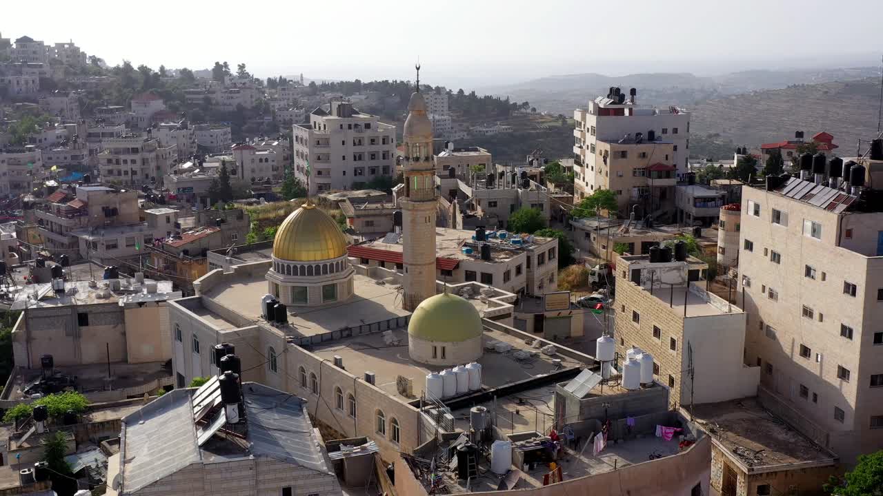 Aerial View of an Ancient Mosque with a Golden Dome and Minaret in a Middle Eastern Town