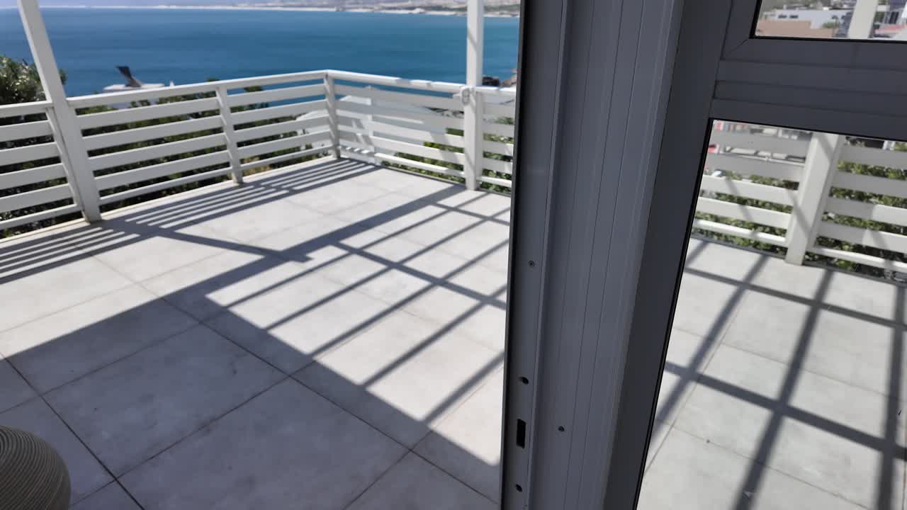 abriendo puertas a una terraza con una hermosa vista del océano durante los viajes a sudáfrica