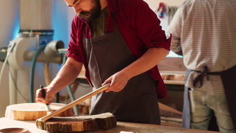 woodworking expert in studio doing putting coats of oil on wood plank