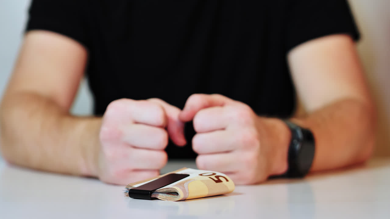 Angry male hand grabs euro cash in dim interior with dark shirt slow motion