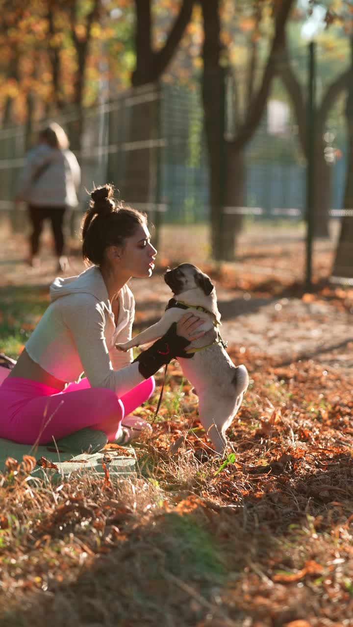 mujer y su pug en un parque de otoño