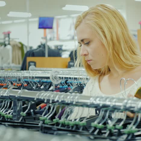 young woman chooses clothes in a shop