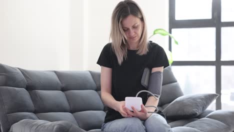 woman measuring her blood pressure at home